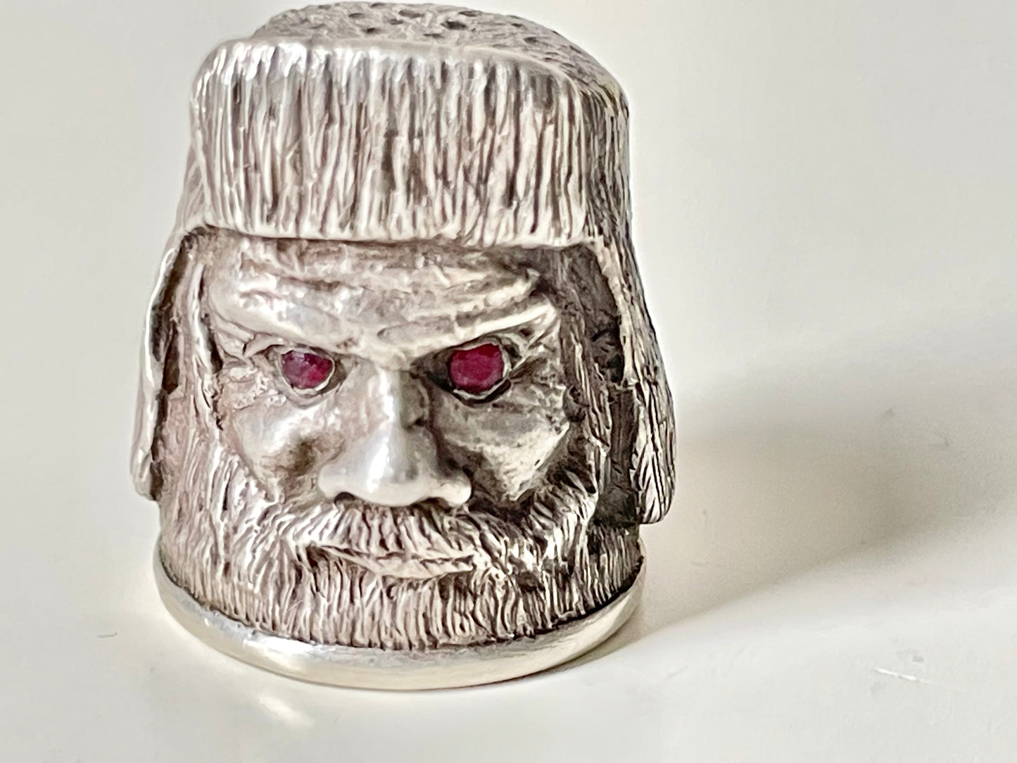Ruby-eyed silver peasant head sewing thimble wearing Faberge mark