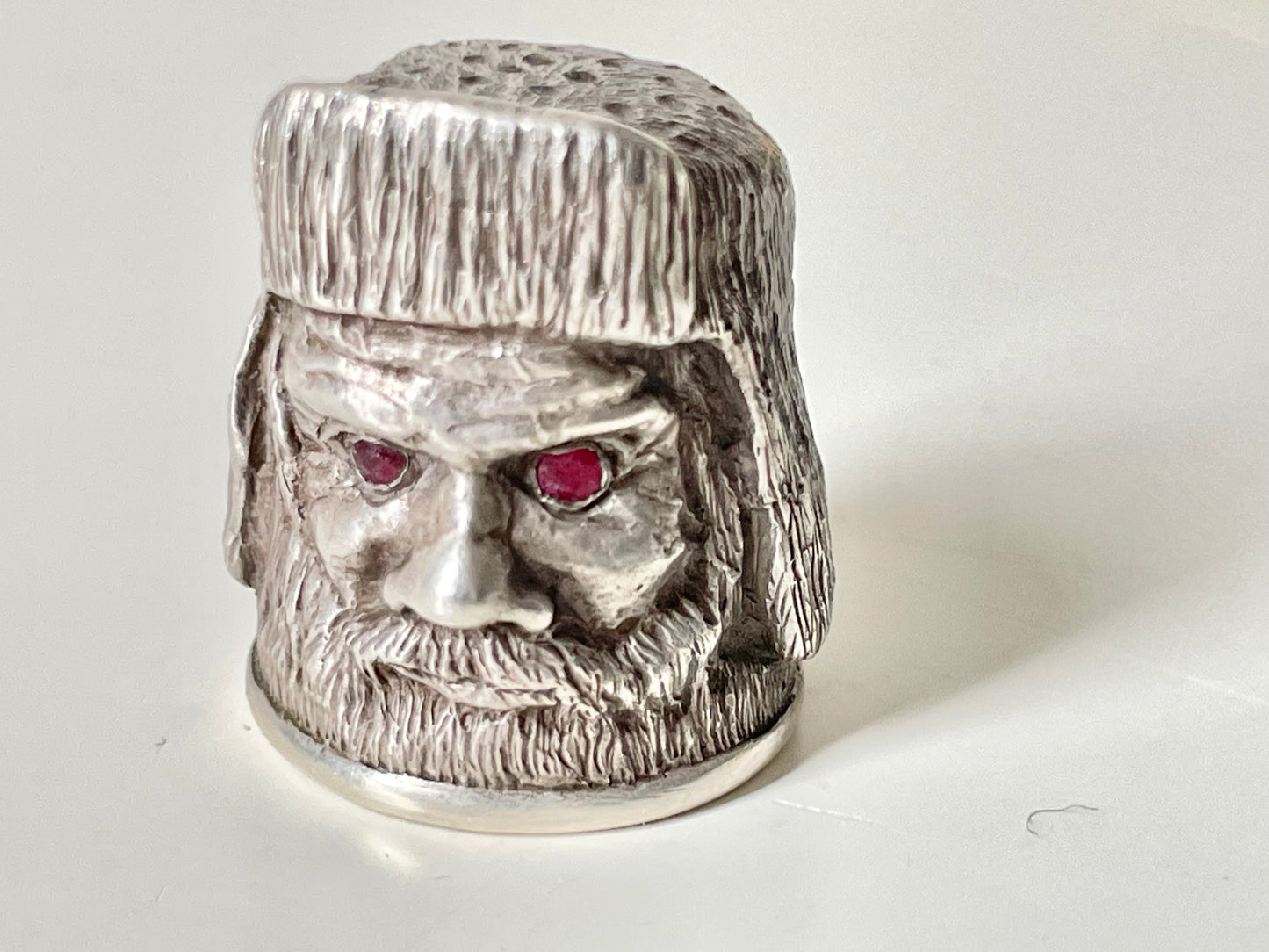 Ruby-eyed silver peasant head sewing thimble wearing Faberge mark