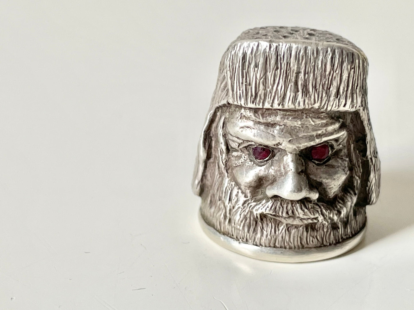 Ruby-eyed silver peasant head sewing thimble wearing Faberge mark