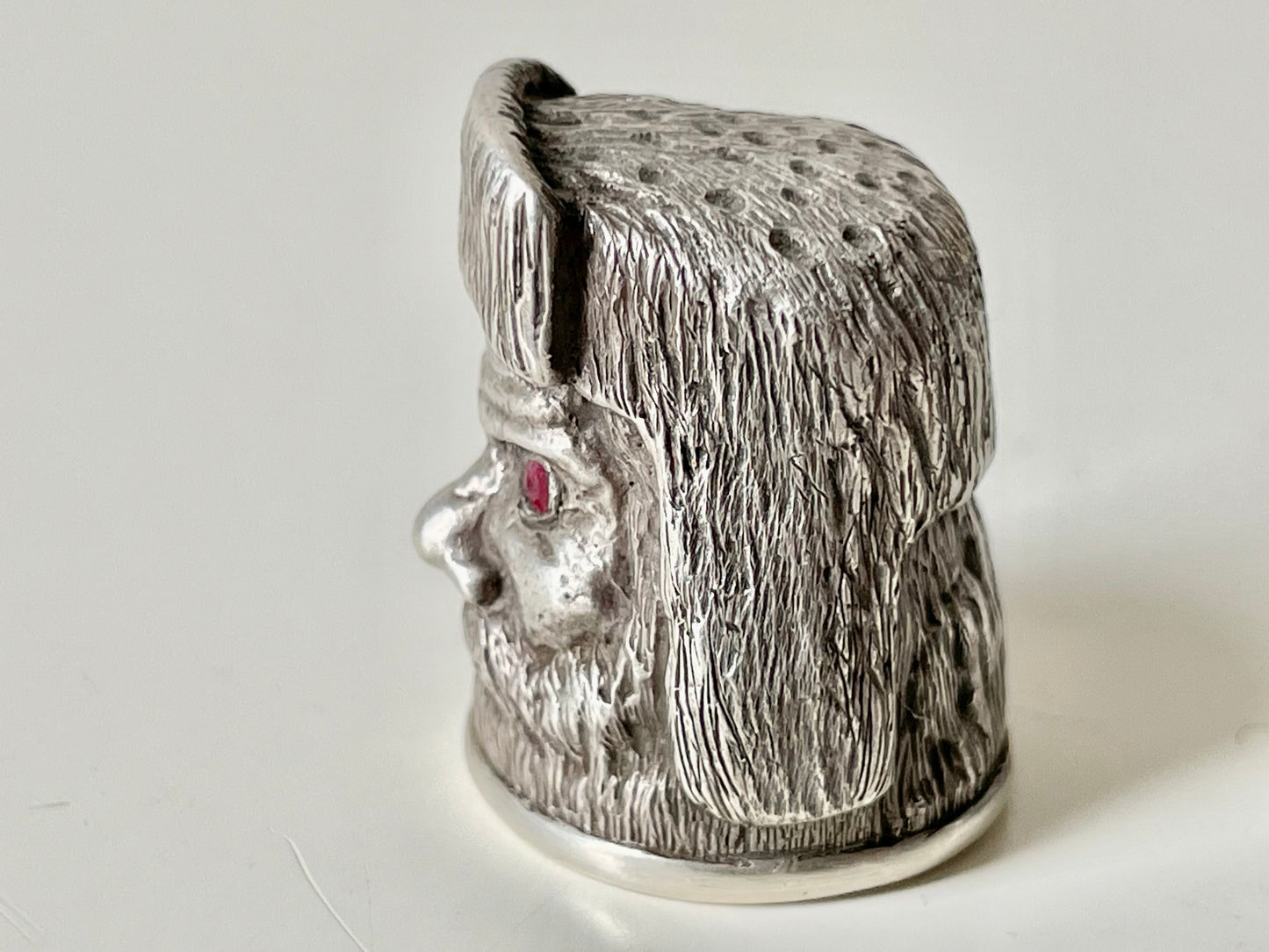 Ruby-eyed silver peasant head sewing thimble wearing Faberge mark